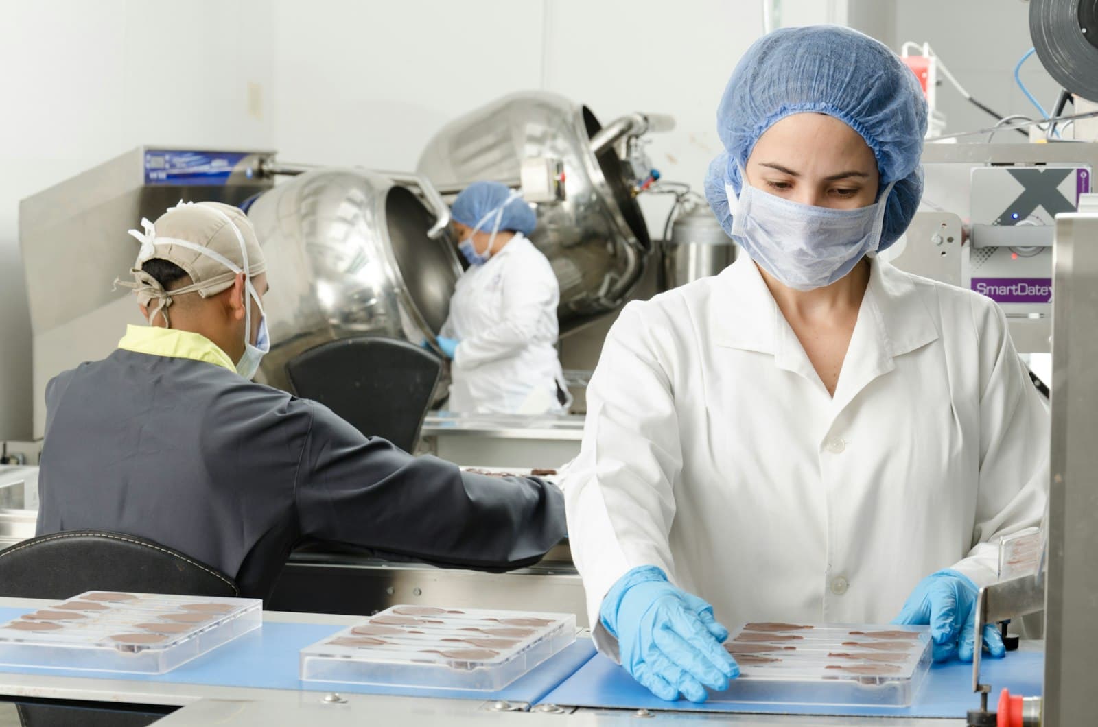 Food safety team in PPE inspecting production in a processing facility